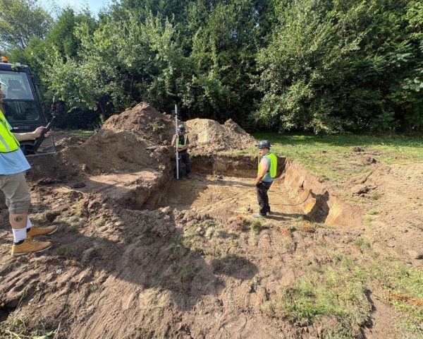 Licensed septic technicians in Ottawa inspecting and measuring excavation for septic system installation