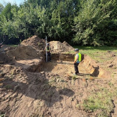 Licensed septic technicians in Ottawa inspecting and measuring excavation for septic system installation