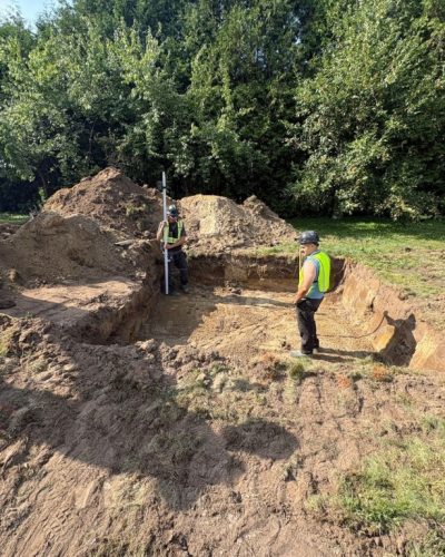 Licensed septic technicians in Ottawa inspecting and measuring excavation for septic system installation