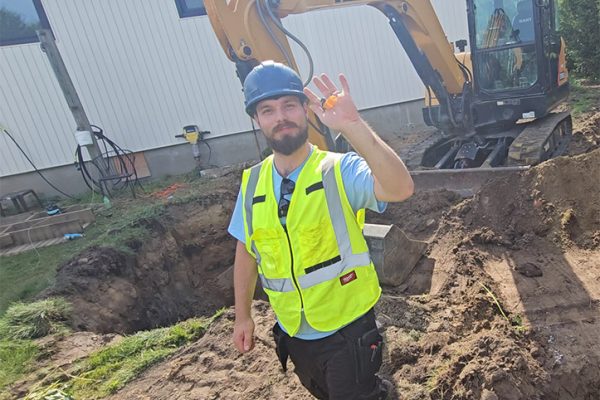 Worker on Septic Repair Ottawa job site with excavator
